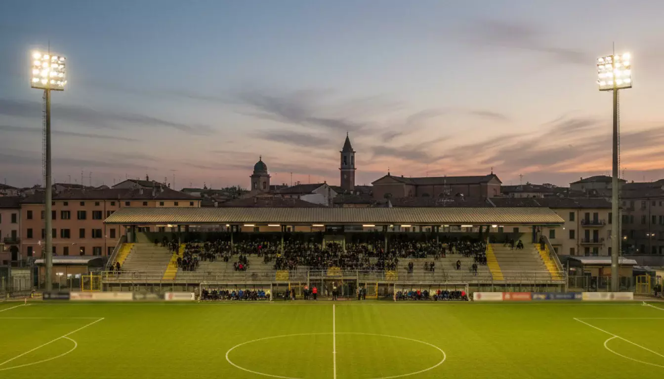 Scommesse Serie B: stadio italiano di provincia con tribuna e campo da calcio in erba illuminato